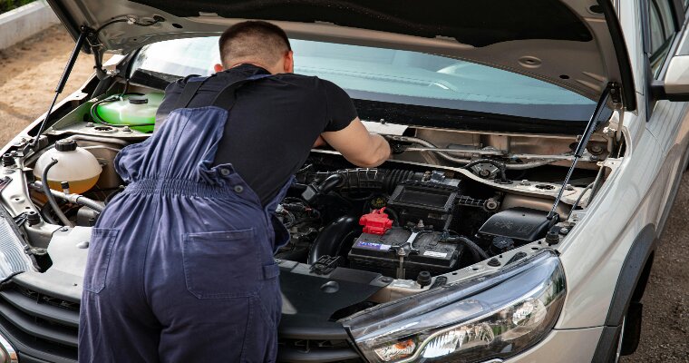 Operaio al lavoro su un'automobile